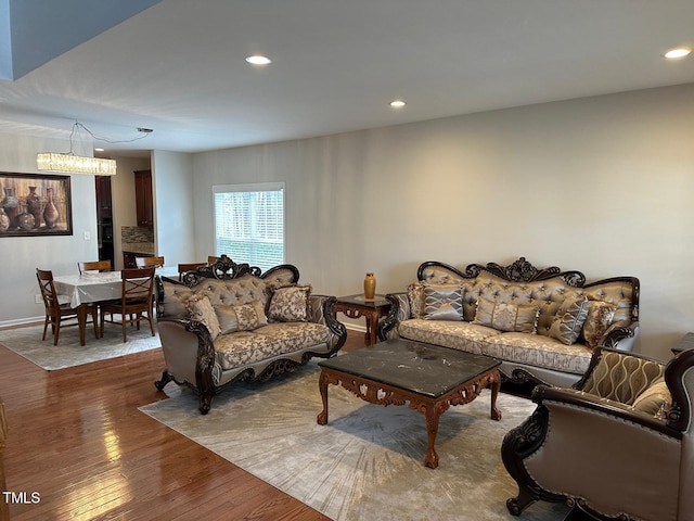 living area with an inviting chandelier, hardwood / wood-style flooring, and recessed lighting