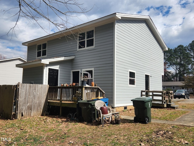 back of house with a deck and fence