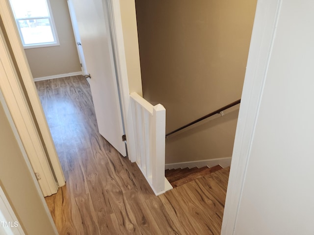 stairs with wood finished floors and baseboards