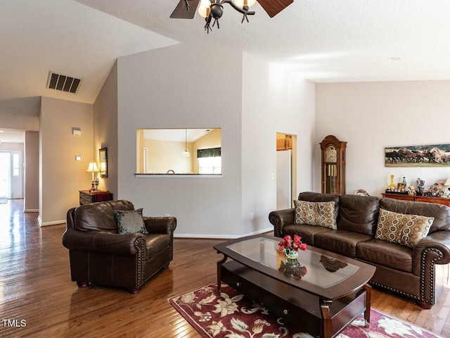 living room featuring visible vents, a healthy amount of sunlight, ceiling fan, and dark wood-style flooring