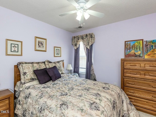 bedroom with visible vents, a textured ceiling, and a ceiling fan