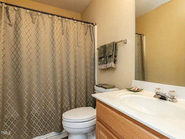 full bathroom with vanity, toilet, and a textured ceiling