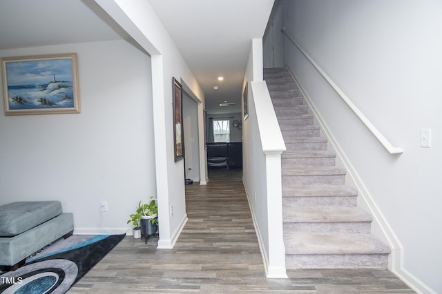 stairway with recessed lighting, wood finished floors, and baseboards