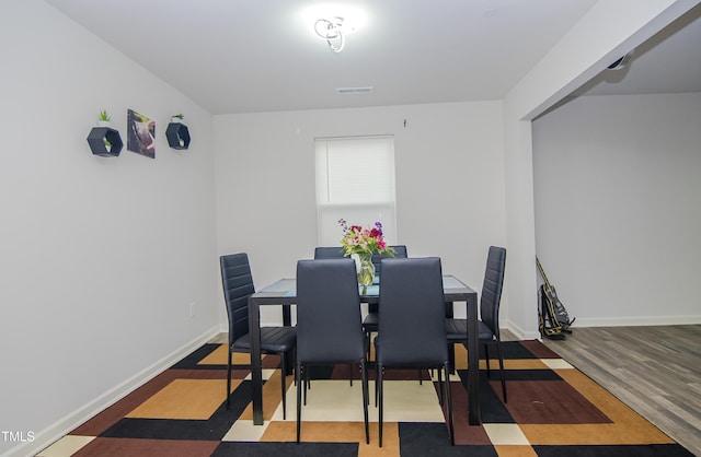 dining area with visible vents, baseboards, and wood finished floors