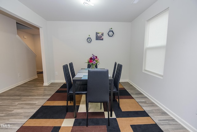 dining space featuring wood finished floors and baseboards