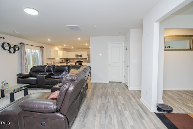 living room featuring recessed lighting, light wood-style floors, visible vents, and baseboards