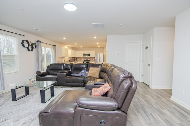 living area with visible vents, recessed lighting, baseboards, and light wood-style floors