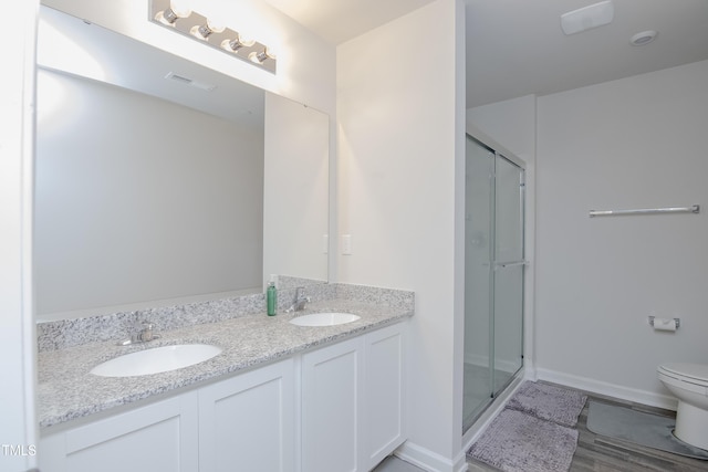 bathroom featuring visible vents, a stall shower, toilet, and a sink