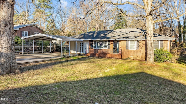 exterior space featuring driveway, brick siding, a detached carport, and a lawn