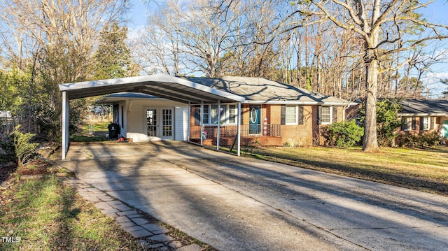 ranch-style home featuring brick siding, concrete driveway, and a front yard