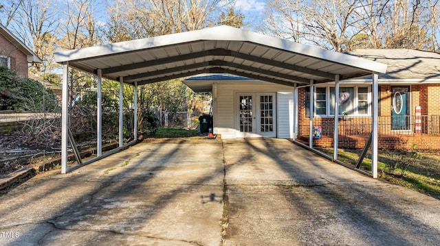 view of parking / parking lot featuring a carport, french doors, driveway, and fence