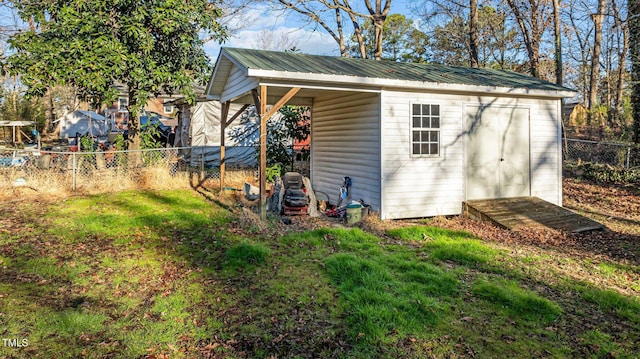 view of shed featuring a carport and a fenced backyard