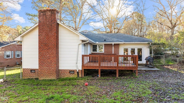 back of house with fence, a wooden deck, a lawn, crawl space, and a gate