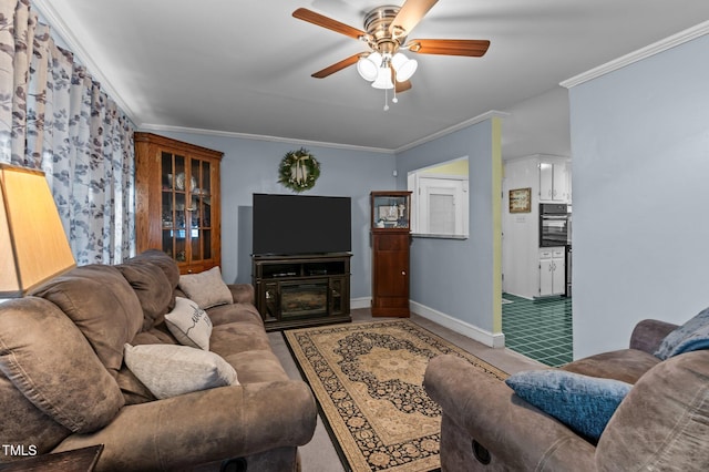 living room featuring a ceiling fan, baseboards, and ornamental molding