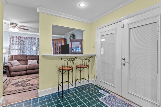 foyer entrance featuring ceiling fan, baseboards, and ornamental molding