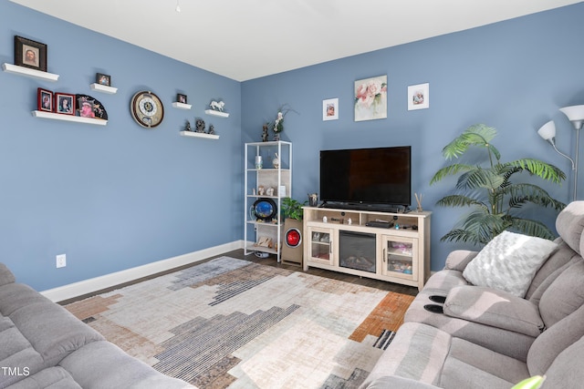 living area featuring baseboards and wood finished floors