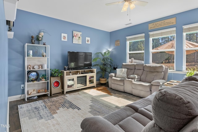 living room with visible vents, plenty of natural light, wood finished floors, and a ceiling fan