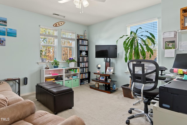 office area featuring a wealth of natural light, carpet flooring, visible vents, and ceiling fan