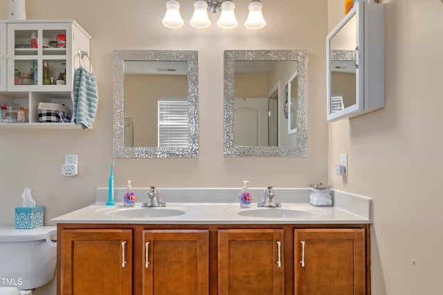 full bath featuring double vanity, toilet, and a sink