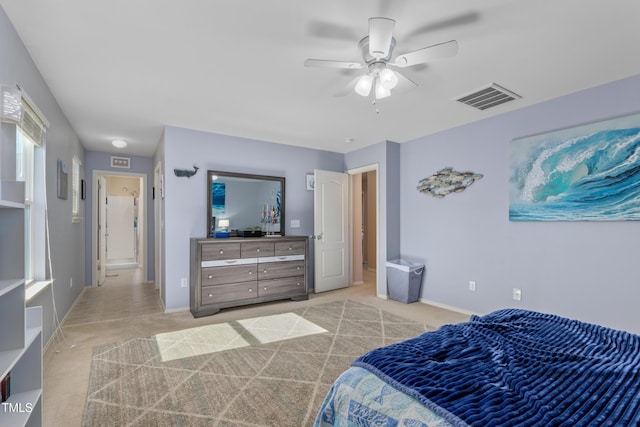 bedroom with visible vents, baseboards, light colored carpet, and ceiling fan