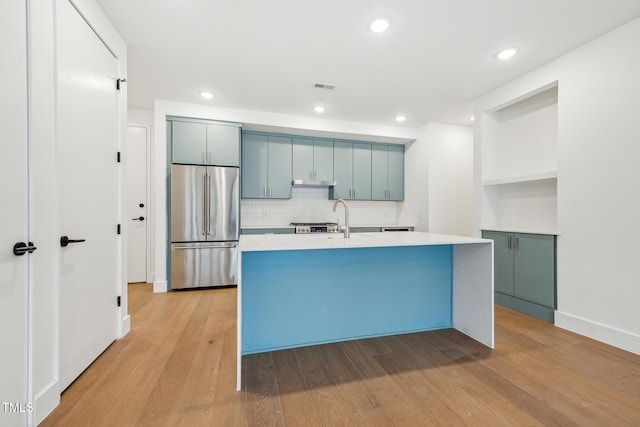 kitchen featuring visible vents, light wood-style flooring, high quality fridge, and light countertops