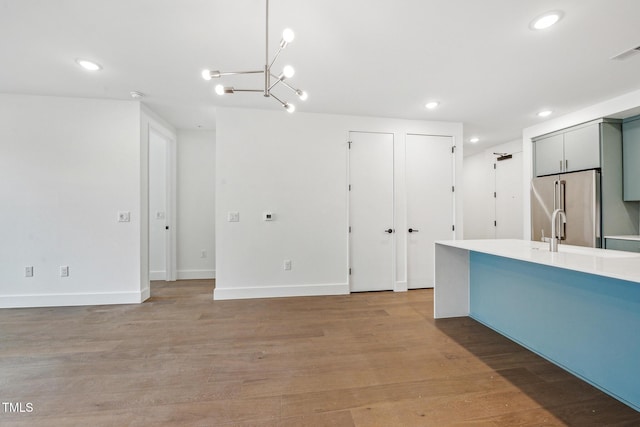 kitchen featuring light countertops, high end refrigerator, recessed lighting, light wood-style flooring, and gray cabinets