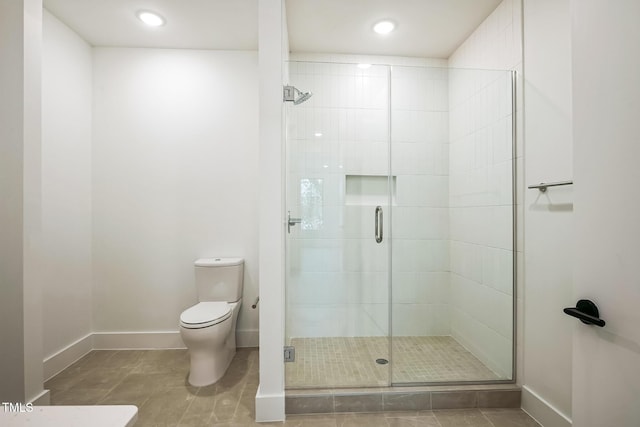 bathroom featuring tile patterned flooring, a shower stall, toilet, and baseboards