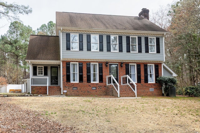 colonial inspired home featuring brick siding, crawl space, a front yard, and a chimney