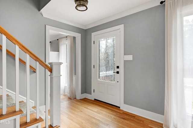 foyer featuring stairway, baseboards, and light wood-style floors