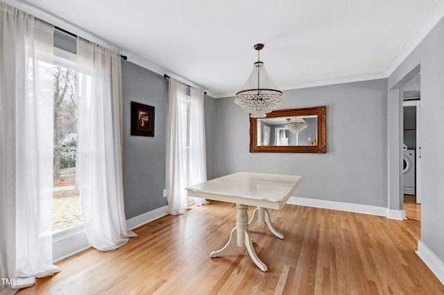 dining room with light wood-style floors, baseboards, and a chandelier