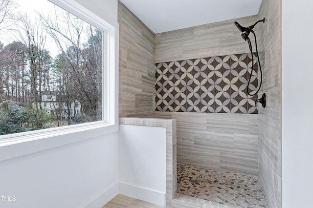 full bath with a wealth of natural light and tiled shower