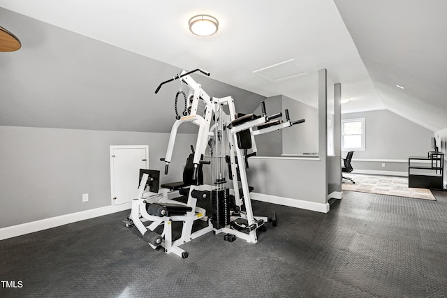 workout room with baseboards, lofted ceiling, and attic access