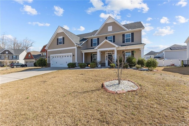 craftsman house with a garage, a front lawn, driveway, and fence