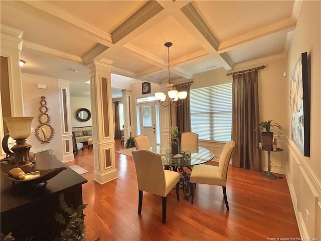 dining area featuring beam ceiling, a decorative wall, coffered ceiling, and ornate columns