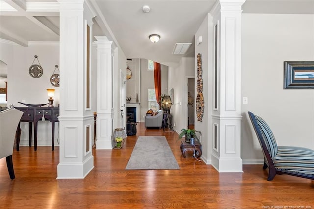 foyer with baseboards, wood finished floors, and ornate columns