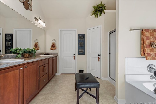 bathroom featuring double vanity, a sink, a garden tub, and a shower stall