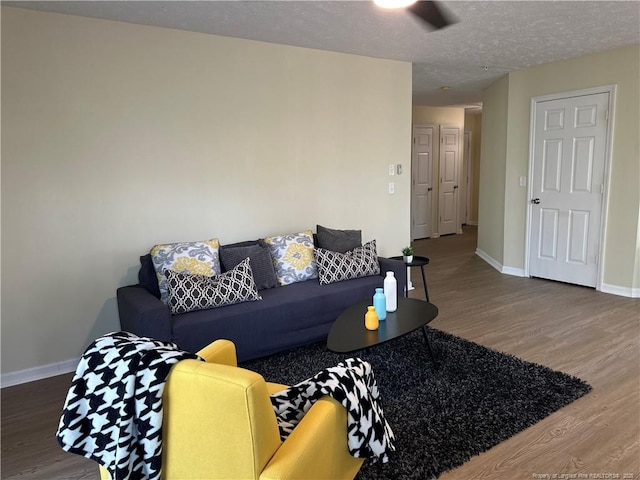 living area with wood finished floors, baseboards, and a textured ceiling