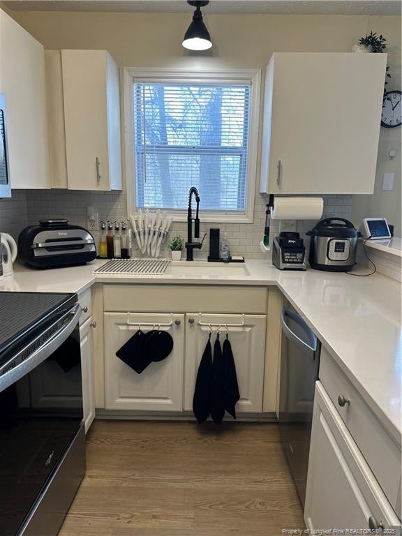 kitchen with dishwasher, white cabinetry, light wood finished floors, and range with electric cooktop