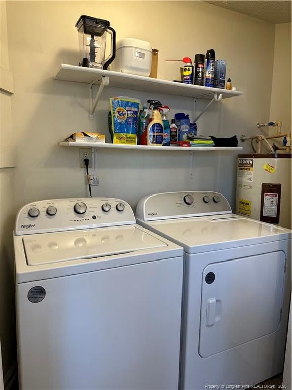 laundry room with laundry area, independent washer and dryer, and water heater