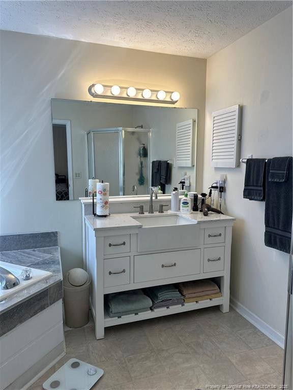 full bath with a bath, a shower stall, a textured ceiling, and vanity