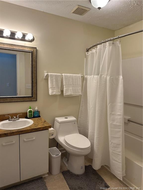 full bath featuring visible vents, a textured ceiling, vanity, and toilet