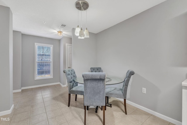 dining area with light tile patterned floors, visible vents, and baseboards