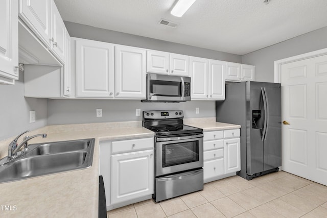 kitchen featuring visible vents, a sink, stainless steel appliances, light countertops, and white cabinets