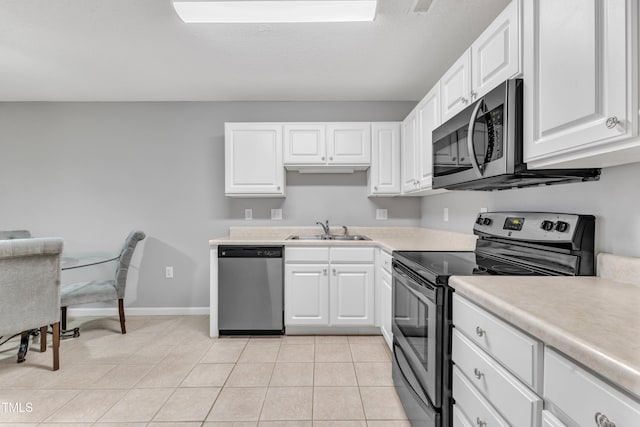 kitchen with a sink, white cabinetry, stainless steel appliances, light tile patterned flooring, and light countertops