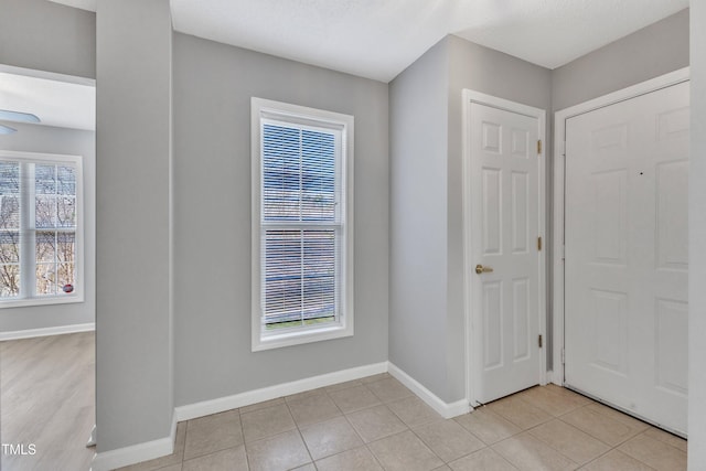 entrance foyer with light tile patterned flooring and baseboards