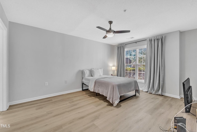 bedroom with visible vents, light wood-style flooring, baseboards, and ceiling fan