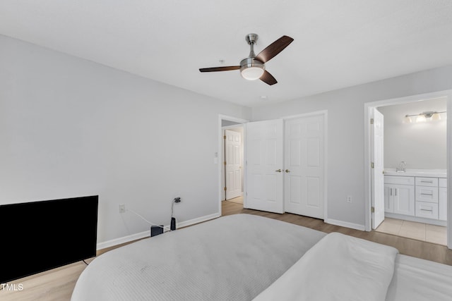 bedroom featuring connected bathroom, baseboards, ceiling fan, and light wood finished floors