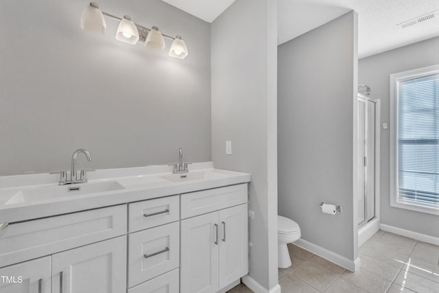 bathroom with tile patterned flooring, visible vents, toilet, and a sink