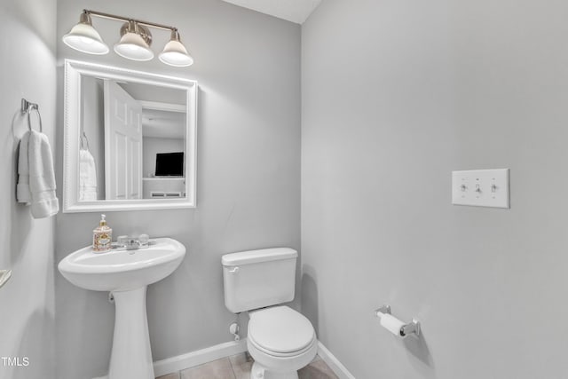 bathroom featuring tile patterned floors, baseboards, and toilet