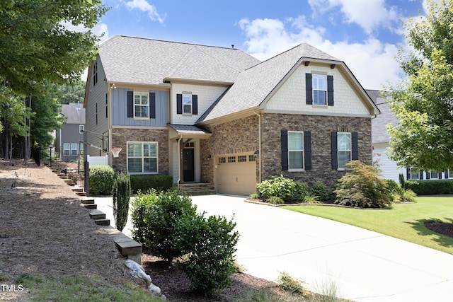 craftsman-style house featuring board and batten siding, a front yard, a garage, stone siding, and driveway